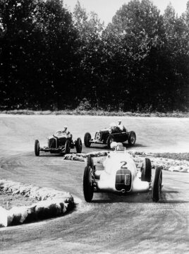 Italian Grand Prix in Monza, September 9, 1934. The winner Rudolf Caracciola (car #2) at the wheel of a "Silver Arrow", the Mercedes-Benz W 25, that he shared with Luigi Fagioli in the event. In the background, you can see a Maserati 6C-34 (car #8), driven by Tazio Nuvolari.  