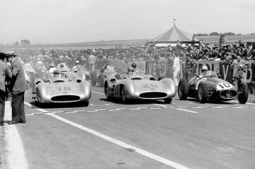 Doppelsieg beim Großen Preis von Frankreich, Reims, 4. Juli 1954. Vor dem Start in der ersten Reihe: Der spätere Sieger Juan Manuel Fangio (Startnummer 18) und der Zweite Karl Kling (Startnummer 20), beide mit Mercedes-Benz Formel-1-Rennwagen W 196 R und Alberto Ascari (Startnummer 10) auf Maserati 250 F.  